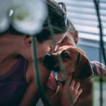 women kissing a dog